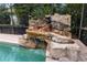 Artificial waterfall feature next to a swimming pool at 9227 Cypress Cove Dr, Orlando, FL 32819