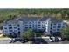 Attractive apartment building featuring light colored siding, a dark roof, and ample parking at 3176 Feltrim Pl # 305, Kissimmee, FL 34747