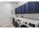 Laundry room with modern washer and dryer and blue cabinets at 32619 View Haven Ln, Sorrento, FL 32776
