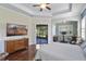 Main bedroom with wood floors, large TV, and backyard access at 32619 View Haven Ln, Sorrento, FL 32776