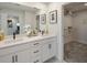 Bathroom showcasing dual sinks, white cabinets, modern fixtures, and a view into the walk-in closet at 3221 Douglas Fir Dr, Apopka, FL 32703