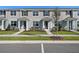A row of inviting townhouses showcases manicured lawns, sidewalks, and modern architecture at 3221 Douglas Fir Dr, Apopka, FL 32703