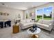 Bright living room featuring an L-shaped sofa, large windows offering backyard views, and elegant decor at 3221 Douglas Fir Dr, Apopka, FL 32703