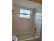 Clean bathroom with tiled walls, a tub, and a window for natural light at 2444 Summerfield Way # 1, Kissimmee, FL 34741