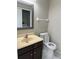 Well-lit bathroom with a vanity, toilet, and a mirror reflecting the laundry area for added convenience at 2444 Summerfield Way # 1, Kissimmee, FL 34741