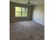 Spacious bedroom with carpet, ceiling fan, and a window overlooking the lush greenery outside at 2444 Summerfield Way # 1, Kissimmee, FL 34741