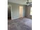 Bright bedroom with neutral walls, closet, ceiling fan, and a window overlooking lush greenery at 2444 Summerfield Way # 1, Kissimmee, FL 34741