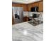 Modern kitchen featuring stainless appliances, wooden cabinets, and a stylish white marble countertop with a sink at 2444 Summerfield Way # 1, Kissimmee, FL 34741