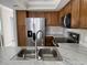 Well-equipped kitchen featuring stainless appliances, wooden cabinetry, and a modern marble countertop with a sink at 2444 Summerfield Way # 1, Kissimmee, FL 34741
