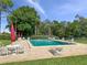 Relaxing community pool surrounded by lounge chairs and lush landscaping at 225 Terrace Hill Blvd # 1C, Debary, FL 32713
