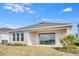 An outdoor patio with sliding glass doors offers serene views of the landscaped backyard at 4678 Ackee Rd, Kissimmee, FL 34758