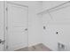 A compact laundry room offers a door to the hallway and a wire rack at 4678 Ackee Rd, Kissimmee, FL 34758