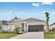 Charming single-story home with a well-manicured lawn, covered porch, and attached two-car garage at 4672 Ackee Rd, Kissimmee, FL 34758