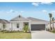 Charming single-story home with a well-manicured lawn and a gray garage door at 4672 Ackee Rd, Kissimmee, FL 34758