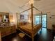 Bedroom features a wooden frame bed and a sliding glass door with outside patio views at 122 Crown Point Cir, Longwood, FL 32779