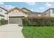 Two-story house with a double garage and manicured hedges at 273 Willow View Dr, Davenport, FL 33896