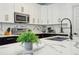 Modern kitchen with white cabinets, quartz countertops, and a black island at 273 Willow View Dr, Davenport, FL 33896
