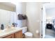 A bright bathroom with a single sink, wood cabinets, and a toilet in a well-maintained condition at 244 Capri Dr, Davenport, FL 33897