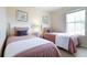 Inviting bedroom with two twin beds, soft pink bedding, and a bright window for natural light at 244 Capri Dr, Davenport, FL 33897