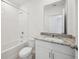 Bright bathroom with a tub and shower combination, white vanity, and granite countertop at 3158 Viceroy Ct, Poinciana, FL 34759
