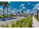 Inviting community entrance with well-manicured landscaping, palm trees, and attractive guard house under a blue sky at 1870 Summer Dr, Davenport, FL 33897