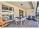 Outdoor patio area with a dining table, chairs, and lounge chairs overlooking pool at 1870 Summer Dr, Davenport, FL 33897