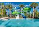 Resort-style pool featuring large, colorful water slides and clear blue water surrounded by tropical palm trees at 1870 Summer Dr, Davenport, FL 33897