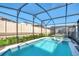 Screened-in pool and spa area surrounded by lush landscaping and a privacy fence at 1870 Summer Dr, Davenport, FL 33897
