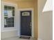 Charming front entrance with classic black door and sidelight window at 524 Hockendale Cv, Sanford, FL 32771