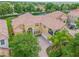 An aerial view showcases this home's elegant tile roof, sprawling layout, and verdant landscaping, surrounded by lush greenery at 334 Chadwick Dr, Davenport, FL 33837