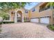 Grand two-story home with a brick driveway and three-car garage at 334 Chadwick Dr, Davenport, FL 33837