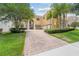 Elegant two-story home featuring a paver driveway, manicured landscaping, and a two-car garage at 334 Chadwick Dr, Davenport, FL 33837