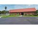 Community clubhouse featuring brick facade, mature landscaping, and ample parking for visitors at 550 Saint Johns Rd, Tavares, FL 32778
