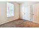 Cozy bedroom with neutral carpet, a bright window, and a closet with double doors at 2543 Old Kent Cir, Kissimmee, FL 34758