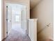 Bright hallway leading to a carpeted bedroom with tray ceilings and a window at 2543 Old Kent Cir, Kissimmee, FL 34758