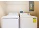 Laundry room with white washer and dryer and shelf at 2543 Old Kent Cir, Kissimmee, FL 34758