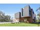 Modern home exterior with gray siding, wood accents, and a three-car garage at 10424 Pocket Ln, Orlando, FL 32836