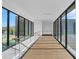 Modern hallway with glass railings, hardwood floors, and large windows at 10424 Pocket Ln, Orlando, FL 32836