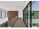 Modern hallway with glass railings, hardwood floors, and large windows at 10424 Pocket Ln, Orlando, FL 32836