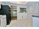 View of the kitchen featuring bright tile flooring, white cabinets, and a pass-through window to the living area at 437 Oak Haven Dr # 437, Altamonte Springs, FL 32701