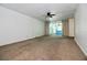 Empty living room with carpet, a ceiling fan, and sliding glass doors leading to the patio at 437 Oak Haven Dr # 437, Altamonte Springs, FL 32701