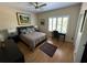 Well-lit bedroom with plank floors, a desk and chair, and a comfortable bed with stylish decor at 8734 Crestgate Cir, Orlando, FL 32819