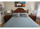 Well-lit bedroom with a blue comforter, wooden furniture, and decorative lamps on bedside tables at 8734 Crestgate Cir, Orlando, FL 32819