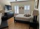 Bedroom with plank floors featuring window shutters, a dresser, and a bed with plush pillows at 8734 Crestgate Cir, Orlando, FL 32819