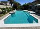 Sparkling pool with a jacuzzi surrounded by lush landscaping and brick pavers, perfect for enjoying sunny days at 8734 Crestgate Cir, Orlando, FL 32819