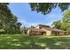 Sprawling single-story home with brick and stucco siding, lush green lawn, and mature trees at 9525 Mcnorton Rd, Altamonte Springs, FL 32714
