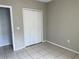 Simple bedroom with tile floors and double doors at 328 Chelmsford Ct, Kissimmee, FL 34758