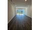 Bright, empty living room with wood floors leading to sliding glass doors and a view of the backyard at 2608 Kinsale Ln, Ormond Beach, FL 32174