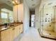 Well-lit bathroom with a glass shower, a stone countertop, and marble floors at 9060 Heritage Bay Cir, Orlando, FL 32836