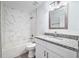 Modern bathroom featuring marble tile surround, granite countertop, and bright vanity lighting at 2240 Center St, Sanford, FL 32771